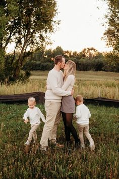 a family standing in the grass with their toddlers