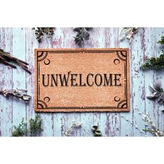 a welcome mat with the word unwelcome on it surrounded by dried herbs