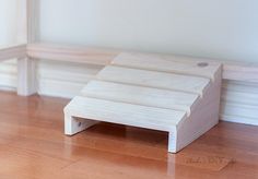 a wooden step sitting on top of a hard wood floor