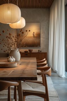 a wooden table topped with vases filled with flowers next to two lamps hanging from the ceiling