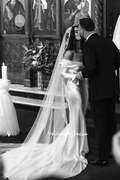 a bride and groom kissing in front of the alter