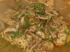 a pile of mushrooms sitting on top of a wooden table next to a bowl of soup