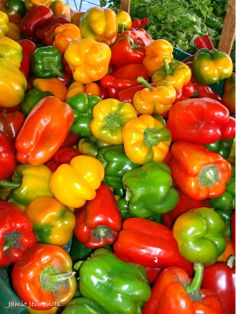 many different colored peppers are in a bin