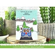 a christmas card with a car driving down the road in front of trees and mountains