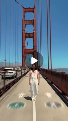 a woman walking across a bridge with cars passing by