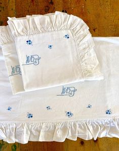 two white bedspreads with blue dog paw prints on them and the words paws written in blue ink