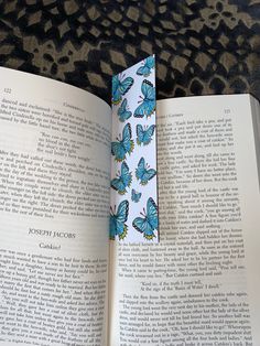 an open book with blue butterflies on it sitting on a leopard print carpeted surface