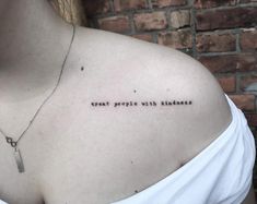 a woman wearing a white shirt has a tattoo on her chest that reads, treat people with kindness