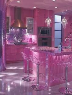 a pink kitchen with two bar stools and an island in front of the counter