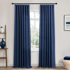 a living room with blue curtains and white walls