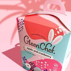 an open box of green chef apple and cranberry cake on a pink background