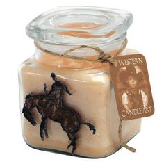 a candle with a horse on it and a label that says western candle co in front of it