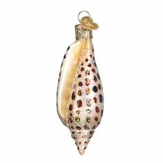 an ornament shaped like a sea shell with a gold and white decoration on it