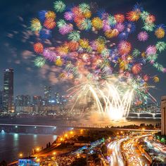 fireworks are lit up in the night sky over a city