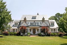 a large white house sitting on top of a lush green field