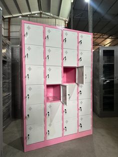 several lockers are lined up in an empty room with pink and white paint on them