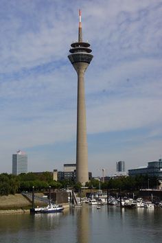 there is a tall tower in the middle of the water and boats are docked around it