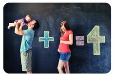 a man and woman standing in front of a blackboard with numbers on it