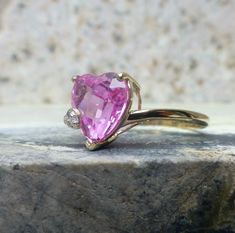 Metal: Solid 10k Yellow Gold Stone: 9x10 mm Pink Topaz and a Tiny Diamond Size: 7 1/4 Weight: 2 grams Era: 1990's This fun ring features a bright pink topaz cut into a heart shape. There is a small diamond set to the side but it is too small to measure or test. The setting standoff height is 6.5 mm. Inside the band their is a makers mark and a gold purity stamp indicating 10k gold. The ring was professionally cleaned and polished and is ready to wear. To view our other listings of fine jewelry click here, https://www.etsy.com/shop/seafarevintage?ref=hdr_shop_menu To help make your decision easier, I am always more than happy to take additional photos. By placing an order you are agreeing to the policies regarding Terms, Conditions, and Shipping located in my store policies section. Your pu Shield Ring, Pink Topaz, Tiny Diamond, Gold Stone, Rings Cool, Diamond Set, Diamond Sizes, Antique Rings, Cleaning Jewelry