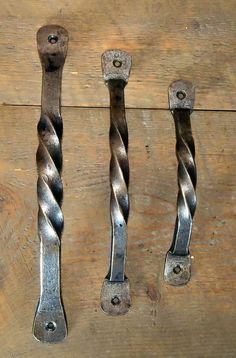 three metal handles on a wooden surface