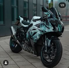 a black and white motorcycle parked in front of a building