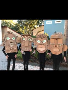 five people wearing cardboard masks with green eyes and brown hair, standing next to each other