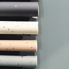 four rolls of toilet paper are lined up against a wall with rust on them and one roll is missing