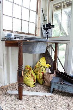 bags of sand sitting on the ground next to a sink in a room with windows