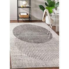 an area rug with a circular design in grey and white colors on a wooden floor