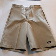 These Dickies Twill Work Shorts Are Perfect For Any Occasion, Whether It's For Travel, Casual Wear, Workwear, Or Even For Business Meetings. They Come In A Solid Beige Color And Have A Relaxed Fit With A 38-Inch Waist Size And An 13-Inch Inseam. The Shorts Feature A Hook & Eye Closure, Slash Pockets, And A Flat Front. Made From A Blend Of Polyester And Cotton, The Shorts Are Durable And Fade-Resistant, Making Them Perfect For Outdoor Activities. They Are Also Wrinkle-Resistant, Ensuring That You Dickies Khaki, Mad Cat, Estilo Cholo, Dickies Shorts, Mens Shorts Outfits, Mens Jean Shorts, Solid Beige, Casual Summer Wear, Fashion Dictionary