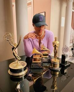 a person sitting at a table with trophies