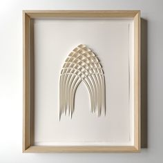 an art piece with white paper cut out of it's sides in a wooden frame