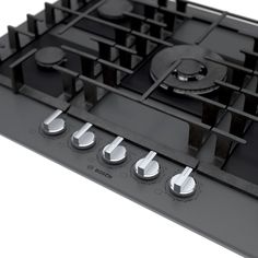 a black stove top with four burners and knobs