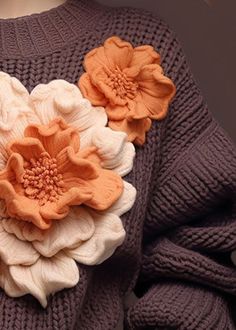 a sweater with flowers attached to it