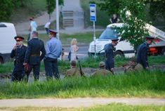 men in uniforms are standing near the grass