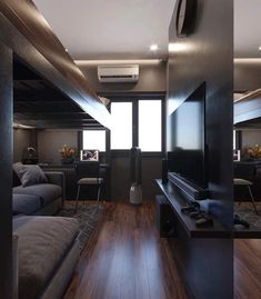 a living room filled with furniture and a flat screen tv on top of a wooden floor