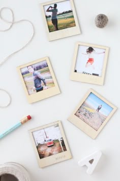 several polaroid frames are hanging on the wall next to a roll of tape and a crayon pencil