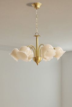 a chandelier hanging from the ceiling in a room with white walls and flooring