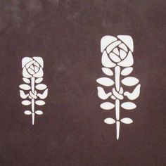 three flower stencils on a black surface