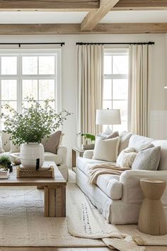 a living room filled with white furniture and lots of window sill space in front of the couches