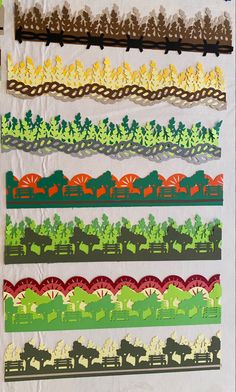 several strips of paper with trees and animals on them