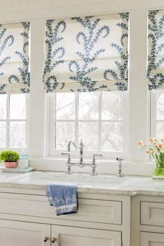 an image of a kitchen window with blue and white roman shades on the windowsill