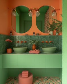 a bathroom with two sinks and mirrors on the wall next to each other in front of an orange wall