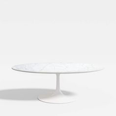 an oval white table with a marble top and pedestal base, viewed from the front