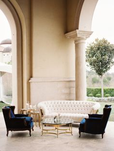 a living room filled with furniture under an archway