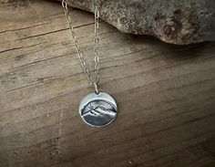 Moonstruck! Half moon over the mountains necklace. 18 inch chain. Perfect gift for mountain lovers and mountain climbers. ~The pendant is made of 99.9% recycled silver. Impressed with a half moon over the mountains design. The surface is rustic, slightly brushed and hand polished to bring out a nice shine that captures the light. As my charms are all made entirely by hand and not by machine using recycled silver they sometimes have slight imperfections which I believe add to their character rather than being a cause for dissatisfaction.  This super lightweight round shaped charm measures 14mm in diameter. See photo next to a penny and ruler plus on my fingers it get an idea of the size of the charm. ~ 1.5mm flat oval cable chain, .925 sterling silver, made in the USA. Sterling silver lobst Mountains Design, Mountain Jewelry, Mountain Necklace, Mountain Climbers, Mountain Designs, Kraft Gift Boxes, Recycled Silver, Mountain Range, Half Moon