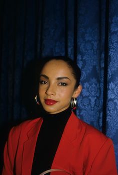 a woman in a red jacket and earrings