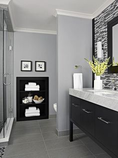 a bathroom with gray walls and white towels on the counter, along with black cabinets