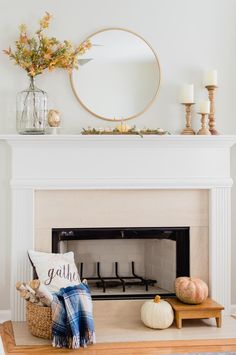 a fireplace with a mirror above it and some pumpkins on the mantle next to it