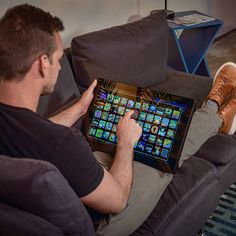 a man sitting on a couch holding an electronic device